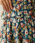 Close-up of the removable fabric belt and button-front bodice on the floral dress.
