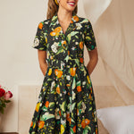 Woman wearing a belted citrus grove fit-and-flare dress with a full skirt.