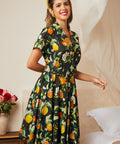 Woman wearing a vintage citrus blossom fit-and-flare dress with a gathered skirt.