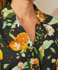 Close-up of the notched collar featuring oranges, lemons, blossoms, and leafy botanical print on a shirt dress.