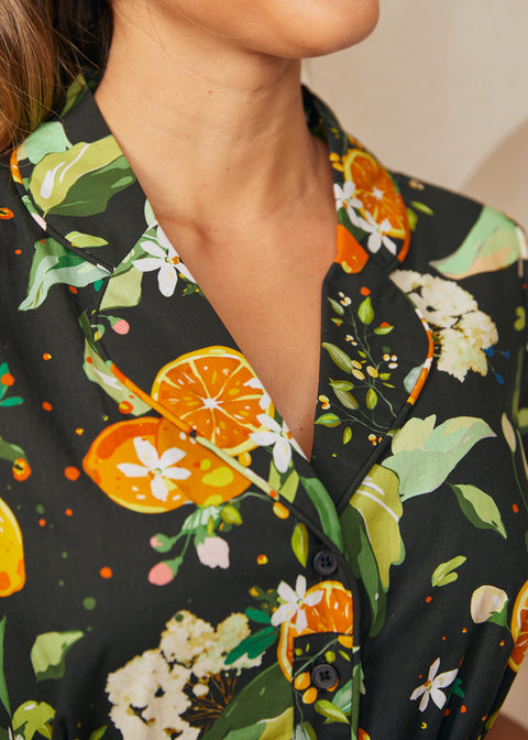 Close-up of the notched collar featuring oranges, lemons, blossoms, and leafy botanical print on a shirt dress.