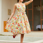 Woman wearing a vintage-inspired faux wrap cotton midi dress with a colorful wildflower print and removable tie belt.