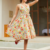 Woman wearing a vintage-inspired faux wrap cotton midi dress with a colorful wildflower print and removable tie belt.