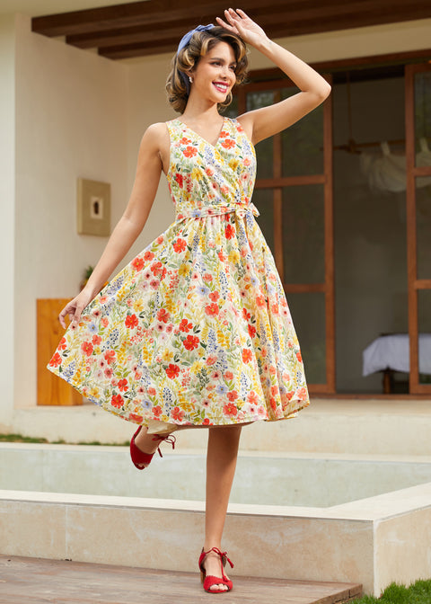 Woman wearing a vintage-inspired faux wrap cotton midi dress with a colorful wildflower print and removable tie belt.