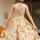 Back view of a vintage-inspired cotton floral dress with an elastic back waist and full skirt.