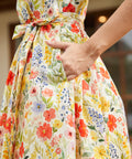 Detail of the side seam pocket and self-tie waist belt on a cotton floral midi dress.