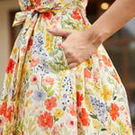 Detail of the side seam pocket and self-tie waist belt on a cotton floral midi dress.
