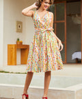 Woman wearing a sleeveless fit-and-flare dress featuring a playful fruit stripe novelty print.