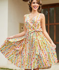 Woman styling a whimsical fruit print cotton dress with side pockets and a flattering faux wrap silhouette.