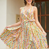 Woman styling a whimsical fruit print cotton dress with side pockets and a flattering faux wrap silhouette.