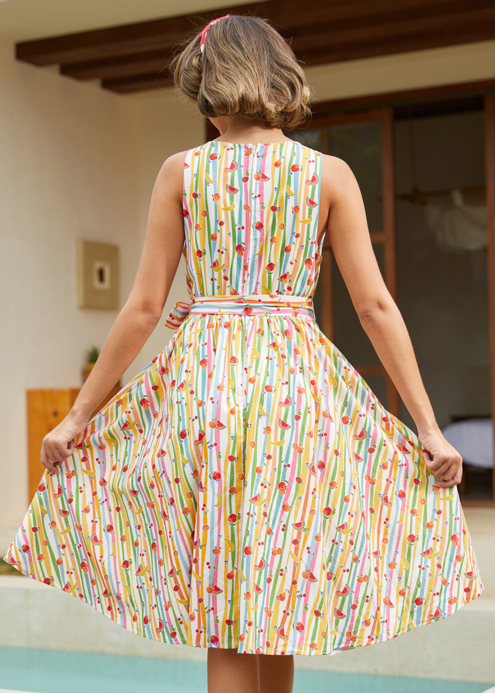 Back view of a sleeveless vintage-inspired cotton dress with a back zipper and full fit-and-flare skirt.