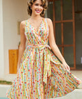Woman wearing a vintage-inspired faux wrap cotton dress with colorful fruit stripes and a removable tie belt.