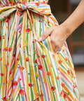 Detail of the removable self-tie sash and side seam pocket on a colorful fruit print cotton dress.