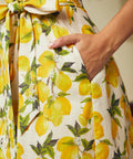 Close-up of the side seam pocket and removable sash belt on a cotton lemon print dress.
