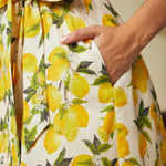 Close-up of the side seam pocket and removable sash belt on a cotton lemon print dress.