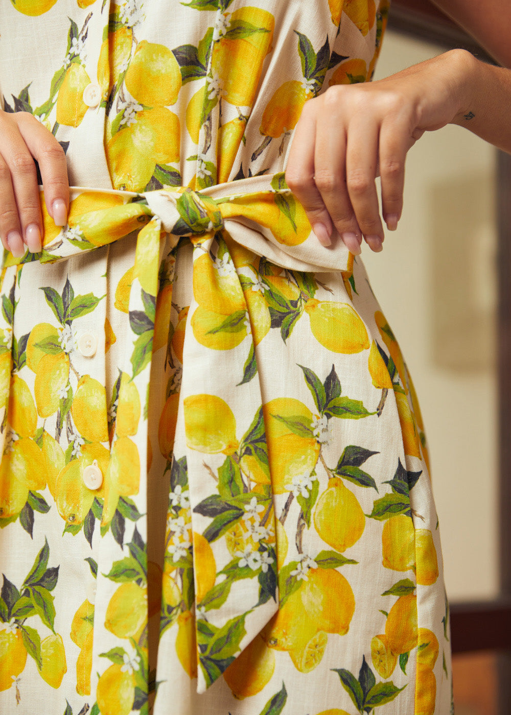 Detail of the removable self-tie waist belt on a lemon print cotton shirt dress.