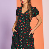 Woman wearing black cherry print vintage-inspired midi dress with puff sleeves and pockets