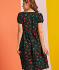 Back view of woman wearing black cherry print midi dress with waist tie