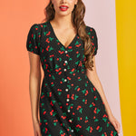 Woman wearing vintage-inspired cherry print midi dress with V-neckline