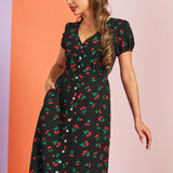 Side angle of cute vintage-inspired black cherry print midi dress with waist tie