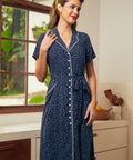 Woman wearing a vintage style navy blue dress with white polka dots and button front