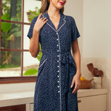 Woman wearing a vintage style navy blue dress with white polka dots and button front