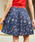 Back view of navy dirndl skirt with ocean-themed print and flared silhouette
