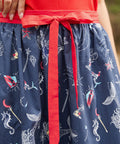 Detail of red contrast waist tie on navy printed wrap skirt