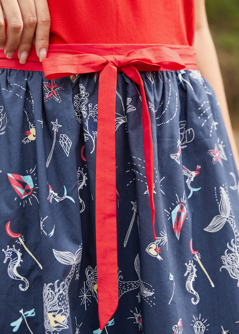 Detail of red contrast waist tie on navy printed wrap skirt
