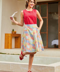 Full outfit view of retro umbrella print skirt styled with red top and sandals
