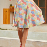 Model wearing colorful umbrella print circle skirt with red sleeveless top, front view