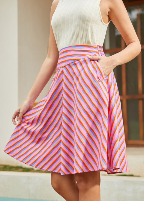 Woman wearing a colorful striped skirt with a neutral background