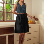 Woman wearing black retro skirt styled with sleeveless polka dot top and spectator heels