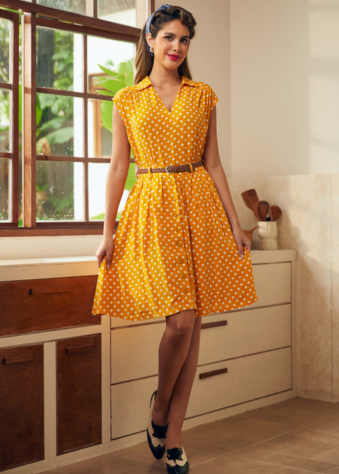 Woman styling retro-inspired yellow polka dot skirt with matching sleeveless top and vintage heels