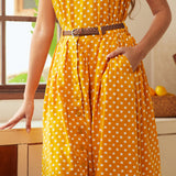Woman wearing a yellow polka dot skirt with a belt in a kitchen setting