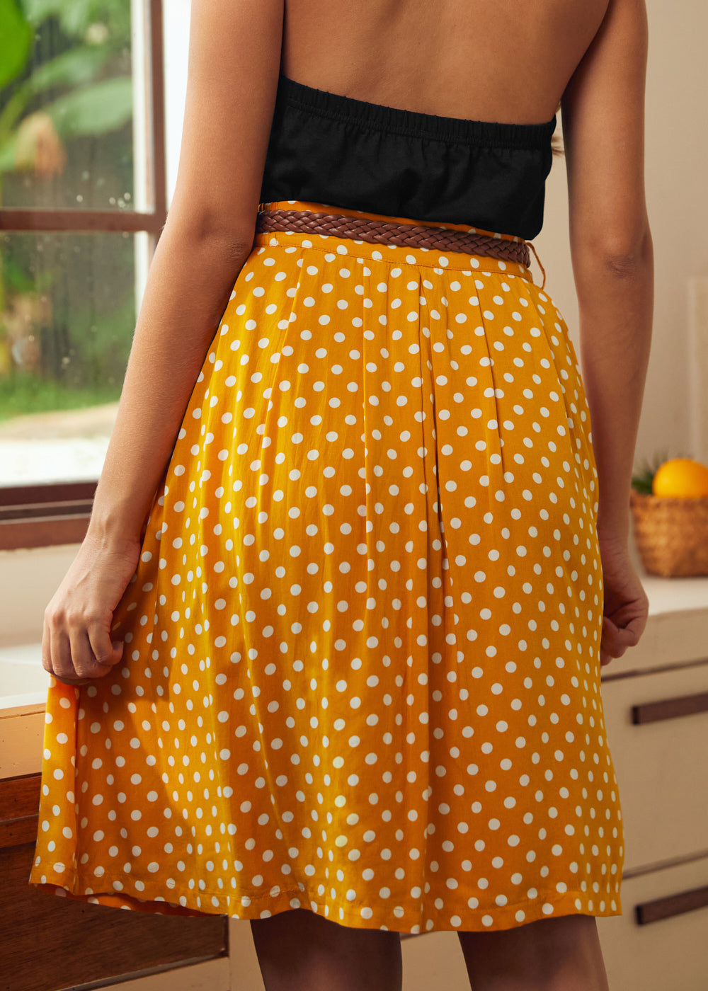 Back view of yellow polka dot gathered skirt with braided belt detail