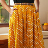 Front detail of yellow polka dot button-front skirt with gathered silhouette