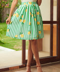 Woman wearing a green and white striped skirt with lemon patterns outdoors.