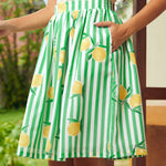 Green and white striped skirt with lemon pattern worn by a woman with her hand in her skirt pocket
