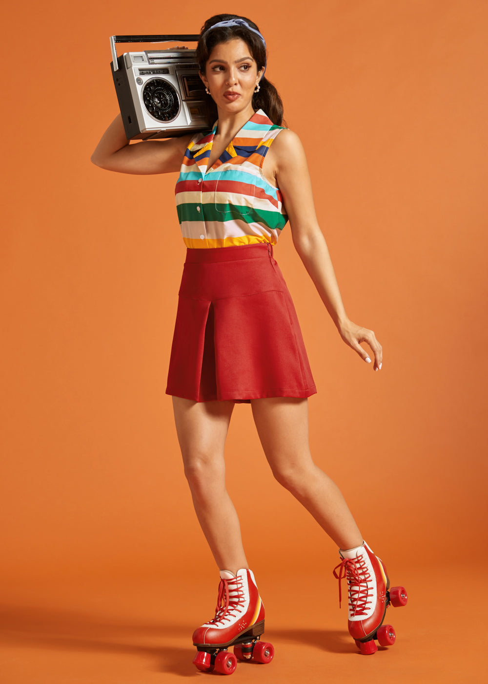 Woman styling a retro-inspired striped button-front blouse with a red mini skirt and roller skates.