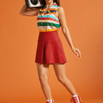 Woman styling a retro-inspired striped button-front blouse with a red mini skirt and roller skates.