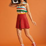 Woman styling a retro-inspired striped button-front blouse with a red mini skirt and roller skates.