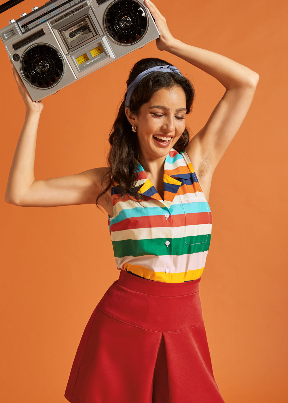 Woman wearing a relaxed-fit striped sleeveless blouse with vintage-inspired styling.