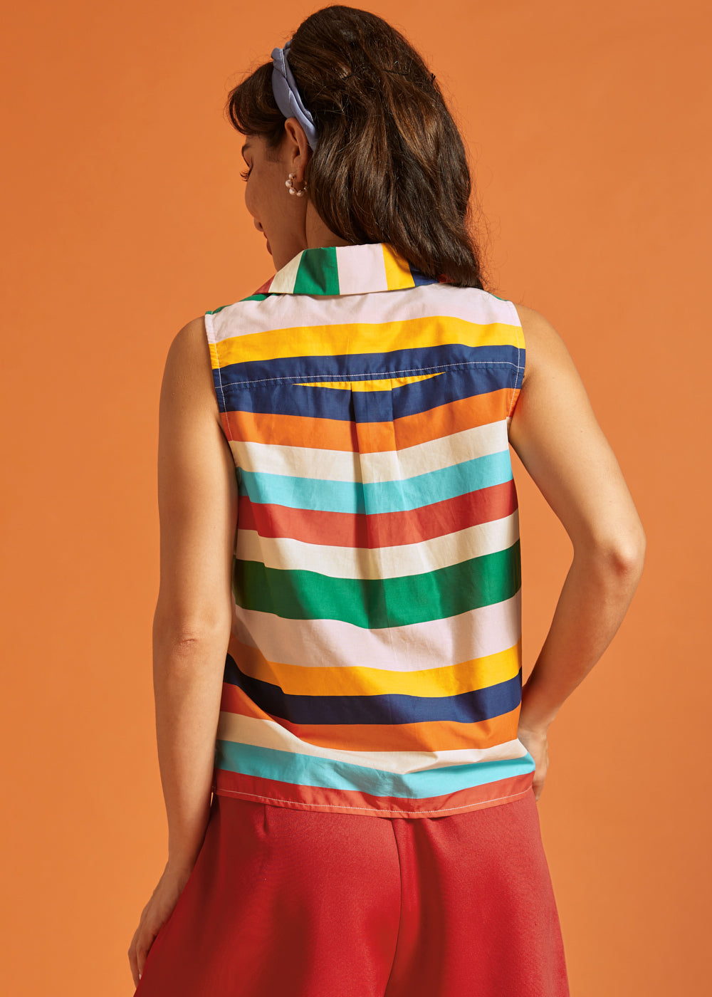 Back view of the sleeveless striped blouse featuring a box pleat detail.