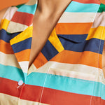Close-up of the camp collar and colorful horizontal stripe pattern on the sleeveless blouse.