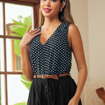 Woman wearing a black and white polka dot sleeveless blouse with button front detail