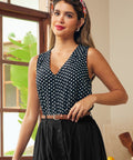 Black and white polka dot button-front blouse with sleeveless silhouette