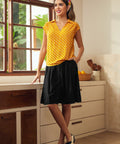 Woman styling vintage-inspired polka dot blouse with retro flats