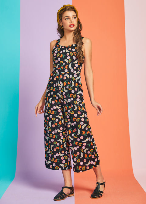 Woman wearing retro-inspired fruit print jumpsuit with cropped legs