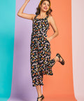 Woman jumping in novelty fruit print cropped jumpsuit